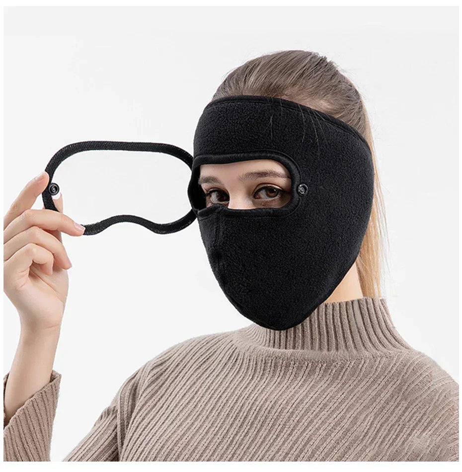 Woman wearing black fleece winter face mask with detachable eye cover, beige sweater