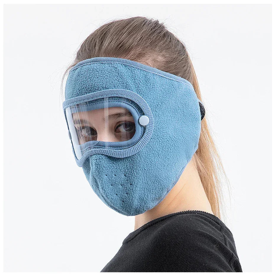 Woman wearing blue fleece face mask with clear eye shield, winter protective gear